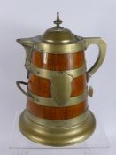 An Oak and Brass Banded Tankard, porcelain lined with classical mask spout, aprox 39 cms high.