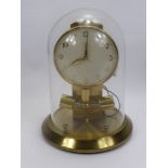 A Junghans ATO Brass Electric Clock, housed in a glass dome.