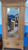 A Vintage Pine Wardrobe, the wardrobe having a mirrored door with drawer below, on raised feet,