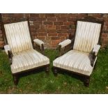 A Pair of Edwardian Arm Chairs, with swept arms, on turned legs and casters, decorative carving to