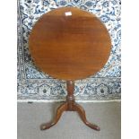 An Antique Mahogany Tilt Top Circular Occasional Table, having turned column support on hoof leg