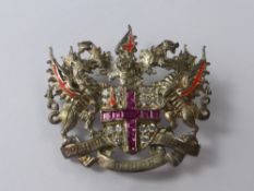 A Silver Heraldic CZ's and Pink Enamel Brooch, the brooch depicting dragons with Latin motto "Domino