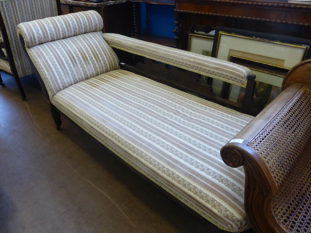 An Edwardian Chaise Longue, mahogany frame, turned legs and casters, covered in a velvet floral