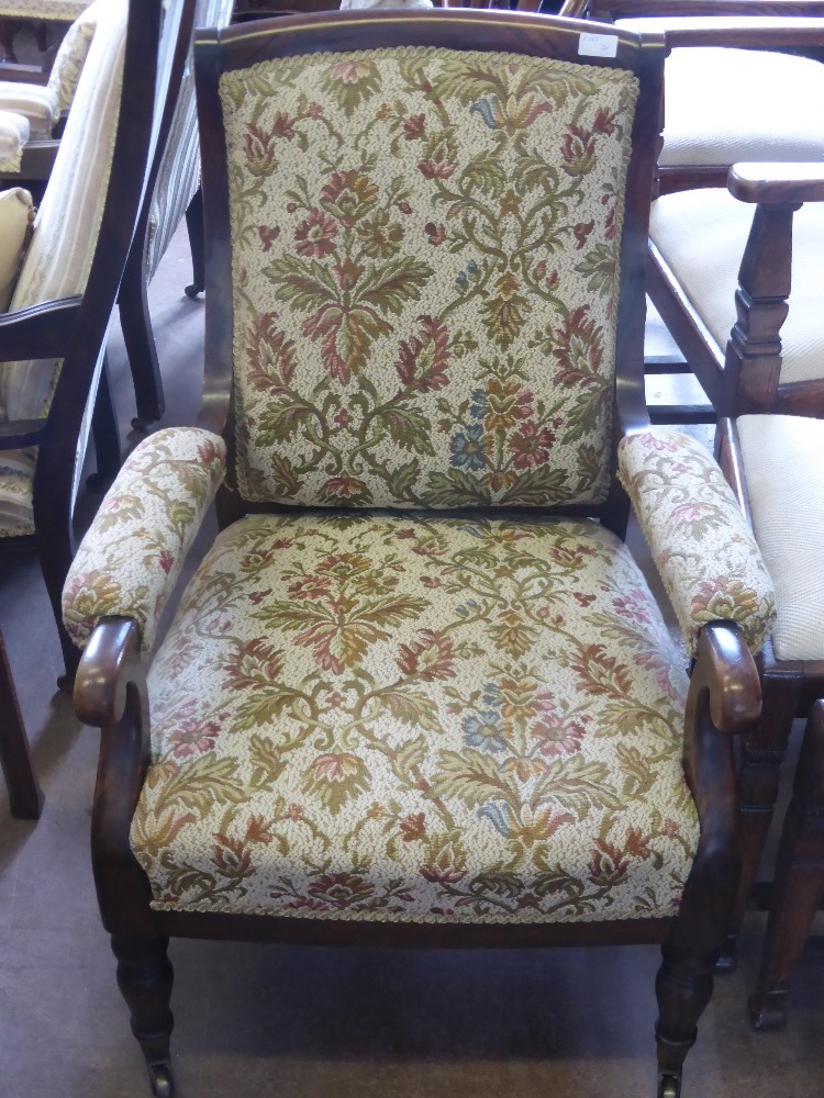 A Victorian Arm Chair, with swept back on turned legs and brass casters, tapestry covering.