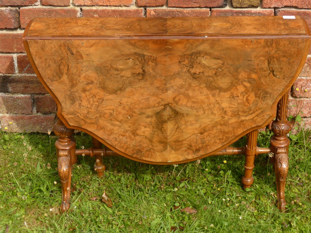 A 19th Century Walnut Veneer Drop Leaf Table, on ornately carved legs and stretchers, approx 109 x