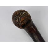 An Antique Walking Stick, the knop carved with an Oriental character with glass eyes and dice in his