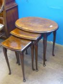 A Walnut and Mahogany Nest of Tables, the oval nest on cabriole legs, approx 57 x 41 x 52 cms.