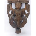 A Teak Siamese Wall Mounted Shelf, depicting a winged deity, approx 48 x 29 cms.