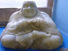 An Antique Chinese Celadon Green Buddha, carved from a single boulder, Buddha depicted seated with