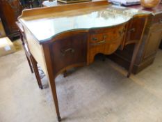 An Edwardian Serpentine Fronted Sideboard, the sideboard having deep drawers to side with single