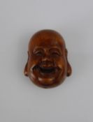 A Japanese Netsuke, in the form of a jolly face, with character marks to base.