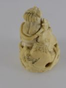 An Antique Carved Ivory Netsuke, with character marks to base, the netsuke depicting a woman with