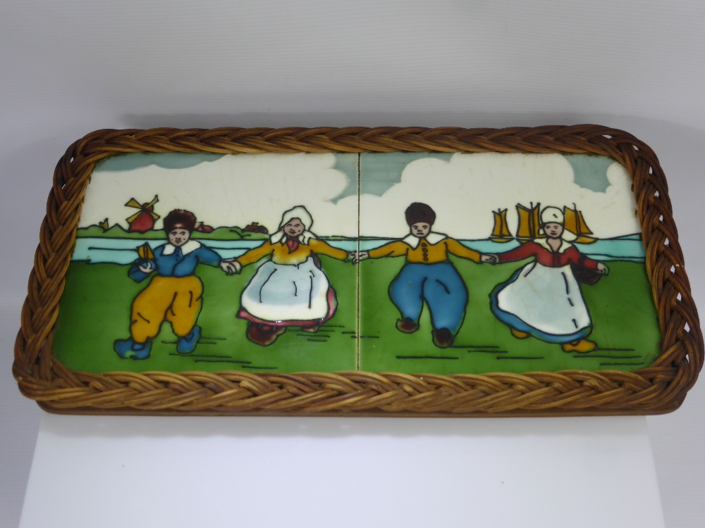 Two Vintage Dutch Ceramic Tiles, depicting characters dancing, the tiles set in a wicker frame,