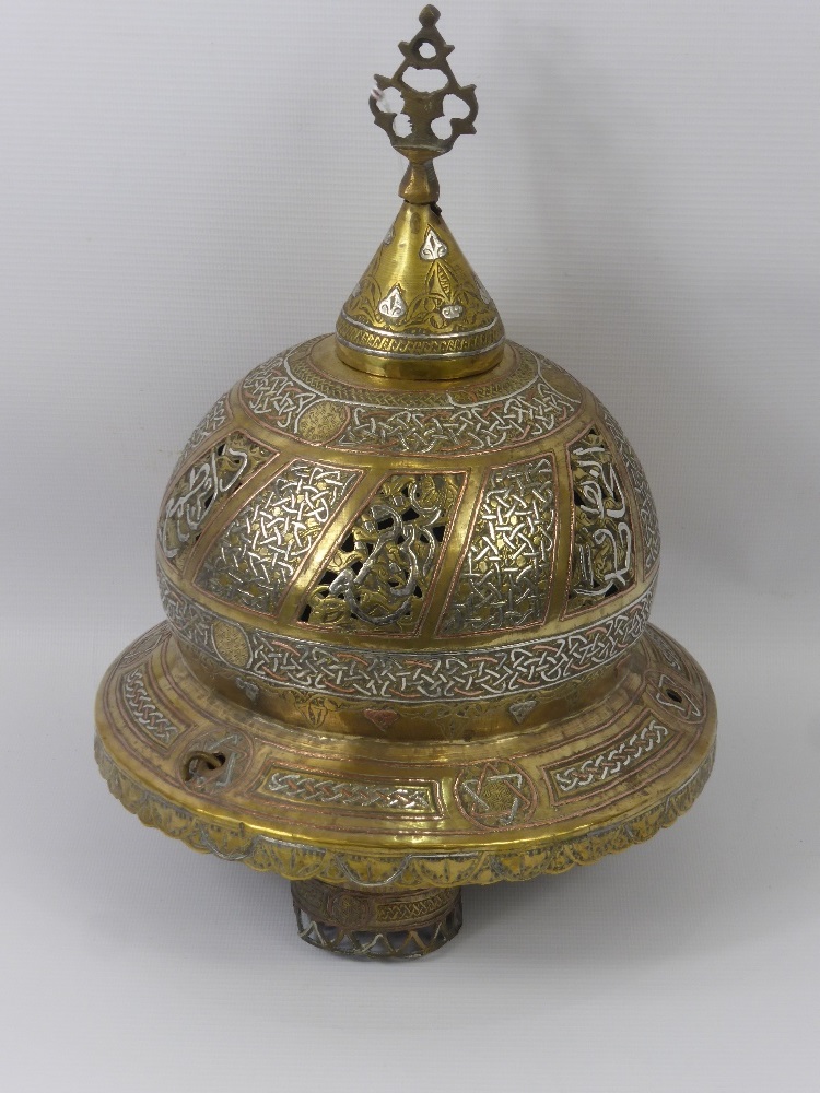 A Brass, Copper and White Metal Lamp, the lamp with Islamic motiff approx 22 cms high.