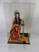 A Circa 1950's Japanese Doll, depicted wearing a Kimono with accessories, approx 40 cms. housed in a