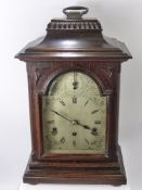 A German Early 20th Century Oak Case Mantel Clock, a silvered face behind bevelled glass door, Roman