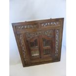 An Elaborately Carved Middle Eastern Style Mirror, the mirror revealed by two slatted doors,