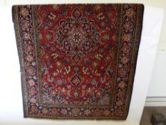 A Turkish Woollen Carpet, floral border, ruby and navy colouring, approx 210 x 134 cms.