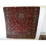 A Turkish Woollen Carpet, floral border, ruby and navy colouring, approx 210 x 134 cms.