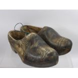 A Pair of Hand Carved Antique Dutch Clogs, together with a pair of wooden cobbler's shoe