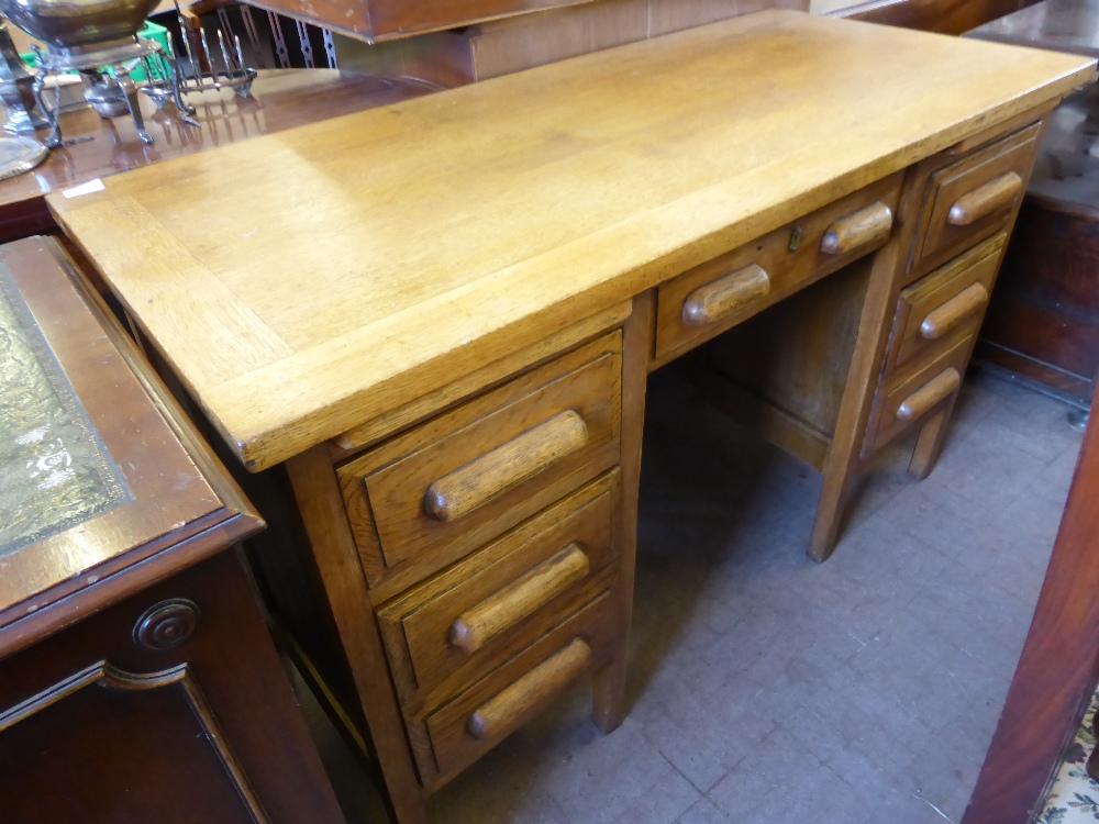 A Mid 20th Century Oak Office Desk, three drawers to either side with one central drawer, raised