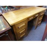 A Mid 20th Century Oak Office Desk, three drawers to either side with one central drawer, raised