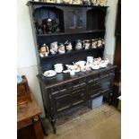 A Stained Oak Dresser, three short drawers with two cupboards beneath and two shelves with a central