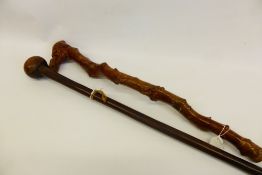 A Briar wood Walking Stick, carved with a grotesque together with a hardwood knop kierie. (2)