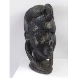 A Hand Carved Sub-Saharan Bust of a Tribal Woman, the woman depicted with elaborate braiding to