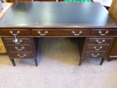 An Edwardian Oak Office Desk, four short drawers to either side and one long central drawer, brass