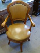 A Contemporary Teak and Leather Captain's Chair, on four splayed feet.