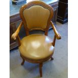 A Contemporary Teak and Leather Captain's Chair, on four splayed feet.