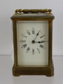 A Brass Carriage Clock, with white enamel face, the carriage clock having numeric and Roman numerals