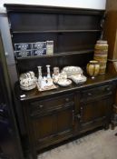 An Ercol Dark Oak Dresser. the dresser having two plate racks, two drawers and panel cupboards