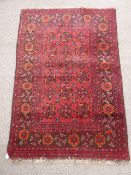 An Afghan Village Rug, with claret and gold floral motif approx 145 x 98 cms.