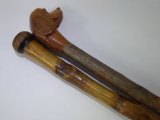 A Hand Carved Hazel Walking Stick, depicting a Spaniel, together with one other. (2)