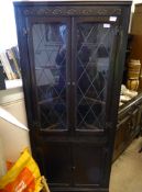 A Dark Oak Astral Glaze Corner Cupboard, the cupboard having two scalloped shelves with glazed top