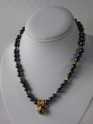 A Lady's Continental 750 (18k) Hematite, Diamond, Sapphire and Gold Beaded Necklace, the necklace