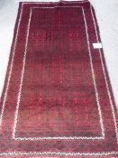 An Afghan Baluch Rug, in claret with twin cream border, approx 226 x 127 cms.