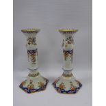 A Pair of Faience Candlesticks, hand painted with flowers, approx 22 cms, painted to base JJ nr
