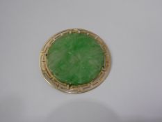 A Chinese Apple Green Jade Disc Brooch, the brooch carved with flowers and in 14 ct gold stylized