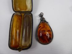 A Lady's Drop Amber Pendant in Silver Metal Mount, together with a pair of cigarette holders