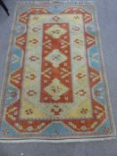 A Woollen Persian Style Carpet, of geometric design with three central guls, orange, blue and gold