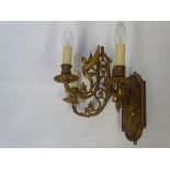 A Pair of Brass Hinged Arm Wall Lights, the lights decorated with winged angels.
