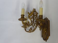 A Pair of Brass Hinged Arm Wall Lights, the lights decorated with winged angels.