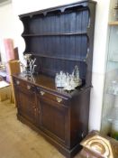 A Dark Oak Vintage Dresser, the dresser having two plate racks with two drawers and cupboards under.