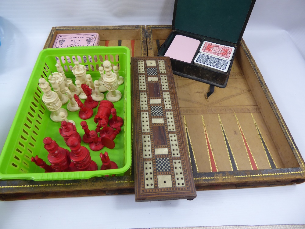An Antique Backgammon, Chess and Drafts Folding Board, together with bone chess pieces, B.P