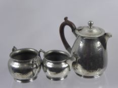 An English Hammered Pewter Coffee Trio, including coffee pot, sugar basin, milk jug.