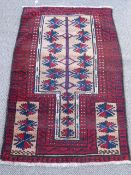 An Afghan Baluch Prayer Rug, with a claret ground and centralised blue and sand coloured Mecca