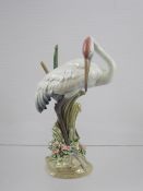 A Lladro Figure of a Crane in Reeds, decorated in muted polychrome with applied flowers and foliage,